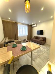a living room with a table and a couch at Аблайхана 1 г in Kokshetau