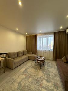 a living room with a couch and a table at Аблайхана 1 г in Kokshetau