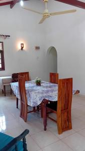 a dining room with a table and some chairs at wkholiday home in Weligama