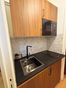 a kitchen with a sink and a microwave at Charming Getaway Near Paris in Alfortville +4 photos