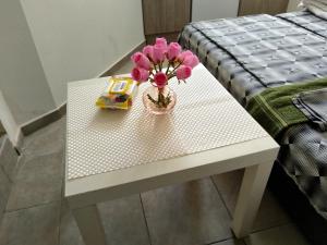 a white table with a vase of pink flowers on it at City Centre Suits 3 in Varna City