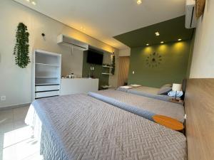 a bedroom with a large bed with a clock on the wall at Pousada Minas Gerais in Araxá