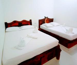two twin beds in a room with white walls at Hotel vacation Doradal in Doradal +10 photos