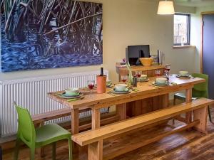 a dining room with a wooden table and green chairs at Saturn 2 - Uk50472 in Greenhaugh