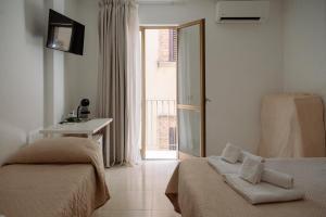 a hotel room with two beds and a window at La Quiete in Scilla