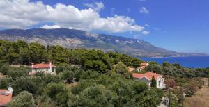 a house on a hill with a lake and a mountain at Aquarius Kefalonia in Pesádha