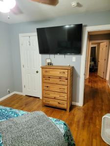 a bedroom with a flat screen tv on a dresser at 5 minutes from Garrison Ave in Fort Smith