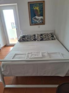 a large white bed in a room with a window at Tini’s Home in Vuno