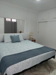 a bedroom with a large bed with blue pillows at Sun and ocean in San Bartolomé +7 photos