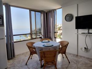 a dining room with a table and chairs with a view of the ocean at Sun and ocean in San Bartolomé