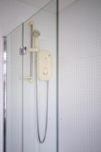 a shower in a bathroom with a shower head at Lombard Hide Away in Inverness +5 photos