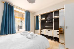 a bedroom with a large bed with blue curtains at Lombard Hide Away in Inverness