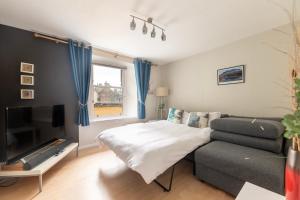 a living room with a bed and a couch at Lombard Hide Away in Inverness
