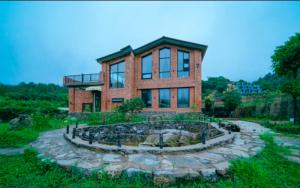 a large brick house with a fountain in front of it at 伴山一墅 in Chaoyang