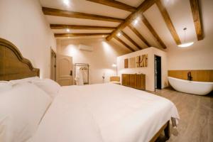 a bedroom with a large bed and a bath tub at 伴山一墅 in Chaoyang