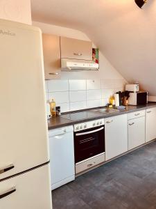 a kitchen with white cabinets and a stove top oven at Apartments Yvonne Sigg in Rust
