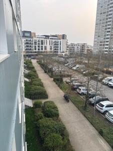 a walkway in a city with parked cars and buildings at Chambre privée dans un appartement partagé in Colombes