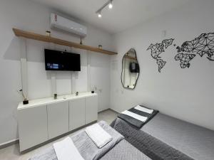 a bedroom with a bed and a tv on a wall at Pousada Minas Gerais in Araxá
