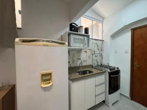 a small kitchen with a sink and a microwave at Pousada Minas Gerais in Araxá +57 photos