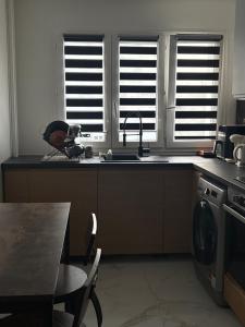 a kitchen with a sink and a counter with a table at Chambre privée dans un appartement partagé in Colombes +3 photos