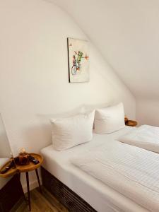 a bedroom with two beds and a painting on the wall at Apartments Yvonne Sigg in Rust