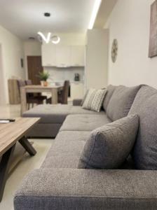 a living room with a gray couch and a table at Ionian Port Suite in Ágios Rókkos