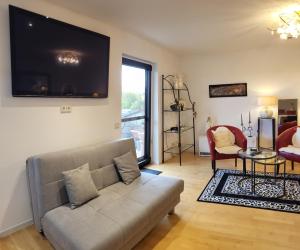 a living room with a couch and a tv on the wall at Lilie in Weilmünster
