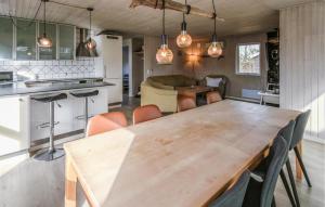 a kitchen and dining room with a wooden table and chairs at 4 Bedroom Amazing Home In Ørsted in Ørsted