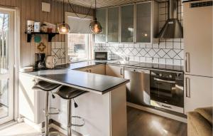 a kitchen with white cabinets and a black counter top at 4 Bedroom Amazing Home In Ørsted in Ørsted +7 photos