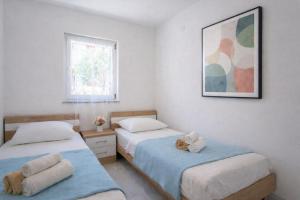 a bedroom with two beds and a picture on the wall at LUNA Residence in Novalja +22 photos