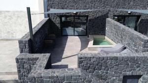 a stone building with a pool in the middle at Santorini Cave Luxury Suites in Fira