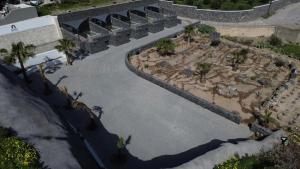 an overhead view of a garden with palm trees at Santorini Cave Luxury Suites in Fira +33 photos