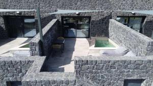 a stone building with a pool in the middle at Santorini Cave Luxury Suites in Fira