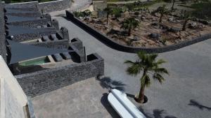an overhead view of a resort with a palm tree at Santorini Cave Luxury Suites in Fira