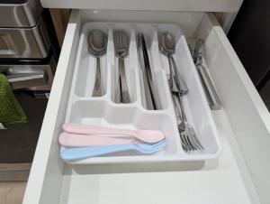 a white tray with utensils in a drawer at Granny's Hug, a cozy 2 Bedroom Basement Suite in Calgary +9 photos