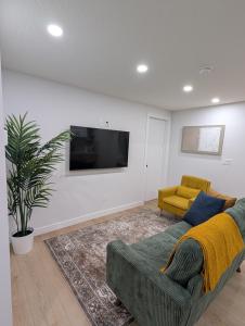 a living room with a couch and a tv at Granny's Hug, a cozy 2 Bedroom Basement Suite in Calgary