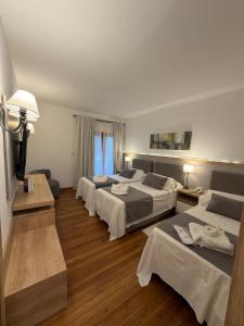 ein Hotelzimmer mit vier Betten und einem Fenster in der Unterkunft Chamonix Posada & Spa in Villa General Belgrano + 45 Fotos