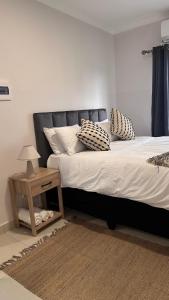 a bedroom with a bed with pillows and a table at The F402 Residence in Gaborone +28 photos
