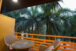 a balcony with a table and chairs and a palm tree at Five Palms Hotel in Gurgaon