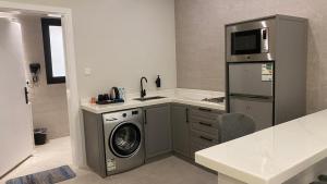 a kitchen with a washing machine and a microwave at luxury royal apartments in Taif