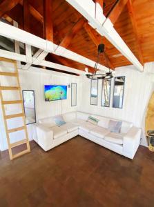 a living room with white couches and a ladder at Paioneal Hostel l Spa Jacuzzi Sauna in El Quisco