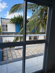 a view of a palm tree from a window at Casa em Condomínio in Bertioga