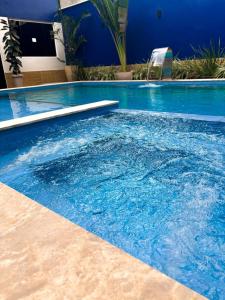 a large swimming pool with blue water at Hotel Dunas e Lençóis in Barreirinhas