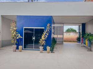 a blue wall with potted plants in front of a building at Hotel Dunas e Lençóis in Barreirinhas