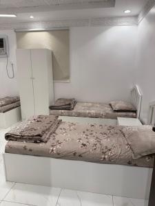 three beds in a room with white walls at رفاه in Medina