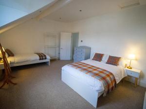 a bedroom with two beds and a dresser and a staircase at The Red Door in Bangor