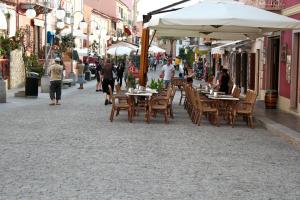 a street with tables and chairs and people walking down the street at Residence Le Pavoncelle in Santa Teresa Gallura