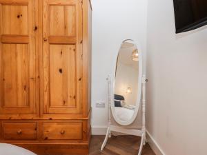 a bedroom with a wooden dresser and a mirror at Shamrock in Exeter +20 photos