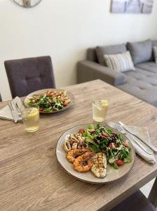 a wooden table with two plates of food on it at Ionian Port Suite in Ágios Rókkos +2 photos