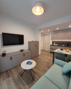 a living room with a couch and a flat screen tv at Libra Aparthotel in Bibione